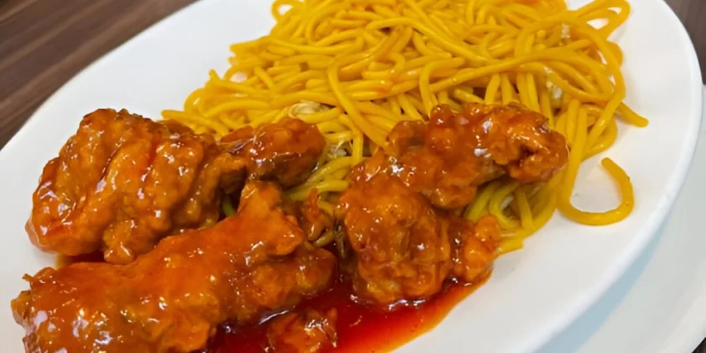 Close-up of crispy hot orange chicken from Panda Express, coated in a flavorful orange glaze with a hint of spice